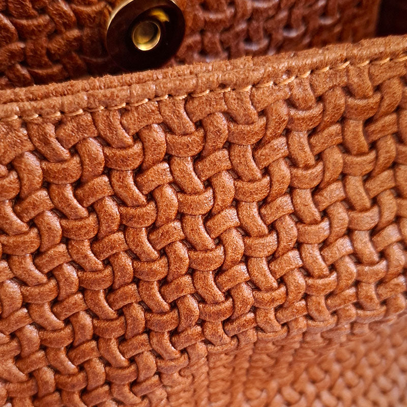 Close up of the Luxurious details of the woven Leather and magnetic button of the TL Keyluck Tote Bag in cognac leather by Montipi Australia with luxurious gold tone hardware signature of premium designer bag