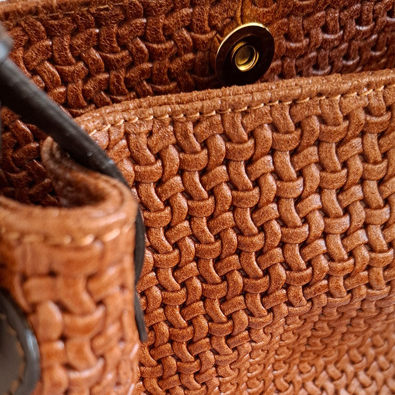 Close up of the Luxurious gold tone magnetic closure button and details of the woven Leather and leather handles of the TL Keyluck Tote Bag in cognac leather by Montipi Australia with luxurious gold tone hardware signature of premium designer bag