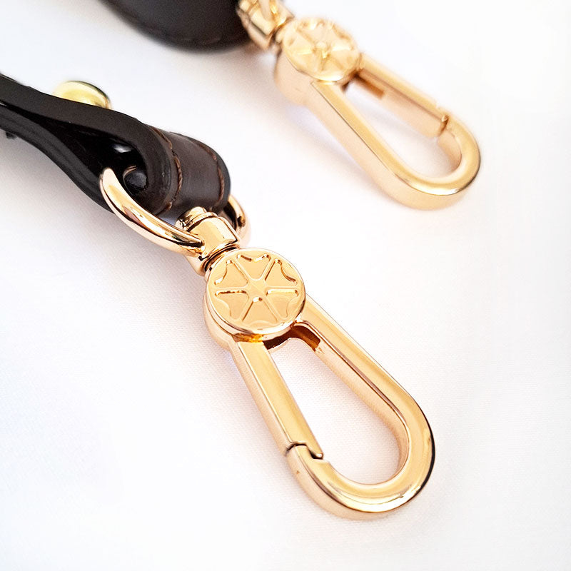 Close up of the detailed engraved design of the Luxurious gold tone hardware fixations of the removable shoulder strap in leather of  the TL Keyluck Tote Bag by Montipi Australia signature of a luxurious designer bag meticulously handcrafted with premium details