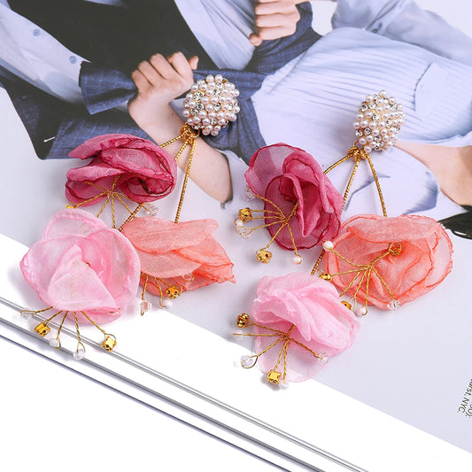 Pink floral hairpins with gold accents on a magazine background