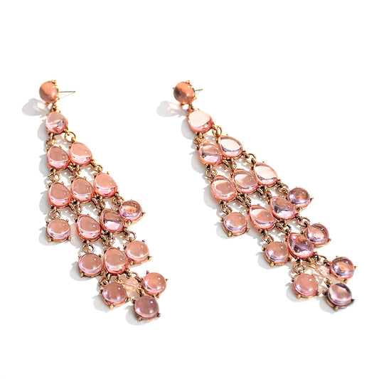 A pair of long tassel drop earrings with pink transparent resin crystals arranged in a cascading design.