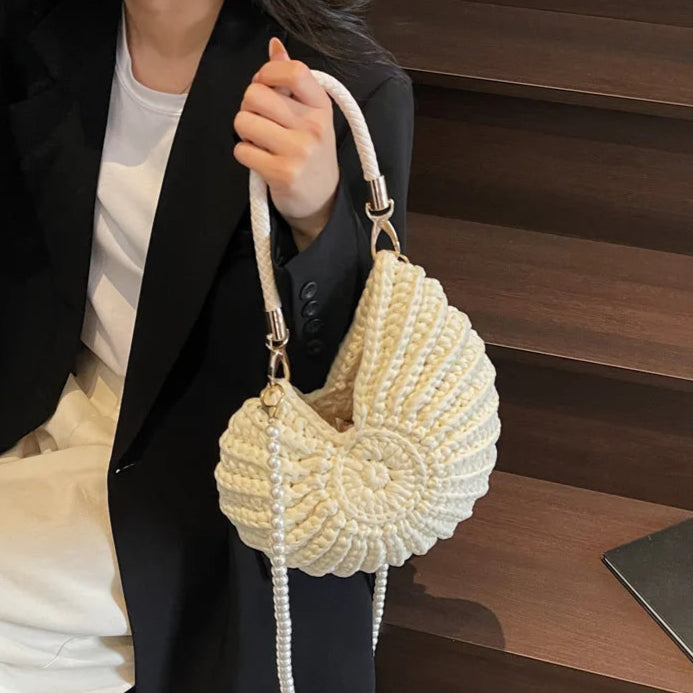 Fossil Seashell Bag in beige cream white  soft woven cotton with shell shape by Montipi, styled in earthy beach tones – perfect for boho luxe, coastal chic, and summer outfits.