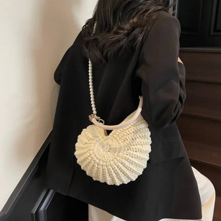 Fossil Seashell Bag in beige cream white  soft woven cotton with shell shape by Montipi, styled in earthy beach tones – perfect for boho luxe, coastal chic, and summer outfits.