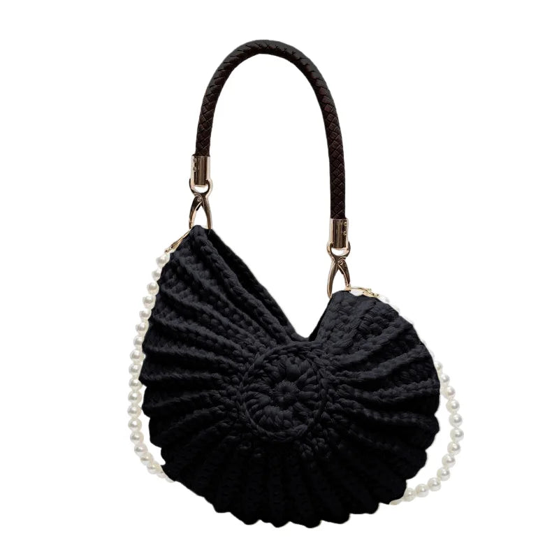 Fossil Seashell Bag in black soft woven cotton with shell shape by Montipi, styled in earthy beach tones – perfect for boho luxe, coastal chic, and summer outfits.