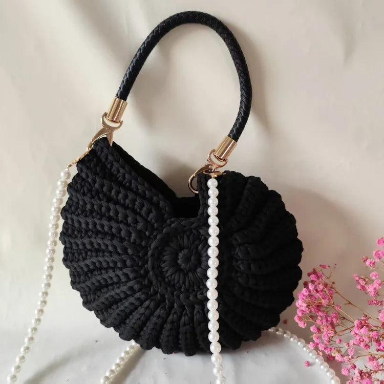 Fossil Seashell Bag in black soft woven cotton with shell shape by Montipi, styled in earthy beach tones – perfect for boho luxe, coastal chic, and summer outfits.