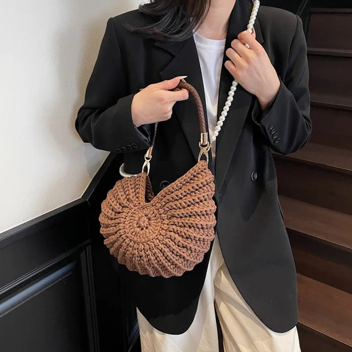 Fossil Seashell Bag in coffee brown soft woven cotton with shell shape by Montipi, styled in earthy beach tones – perfect for boho luxe, coastal chic, and summer outfits.