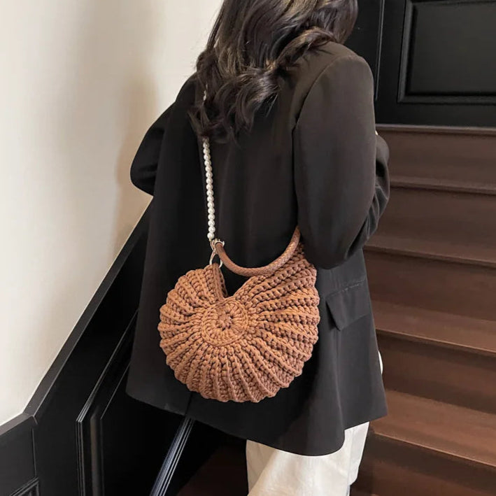 Fossil Seashell Bag in coffee brown soft woven cotton with shell shape by Montipi, styled in earthy beach tones – perfect for boho luxe, coastal chic, and summer outfits.