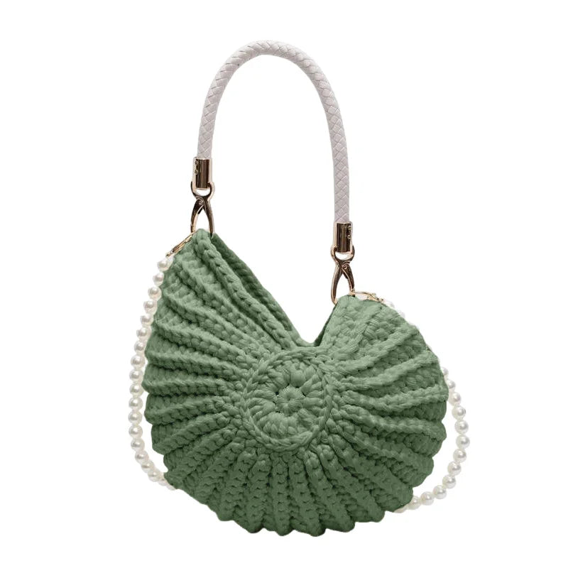 Fossil Seashell Bag in green soft woven cotton with shell shape by Montipi, styled in earthy beach tones – perfect for boho luxe, coastal chic, and summer outfits.