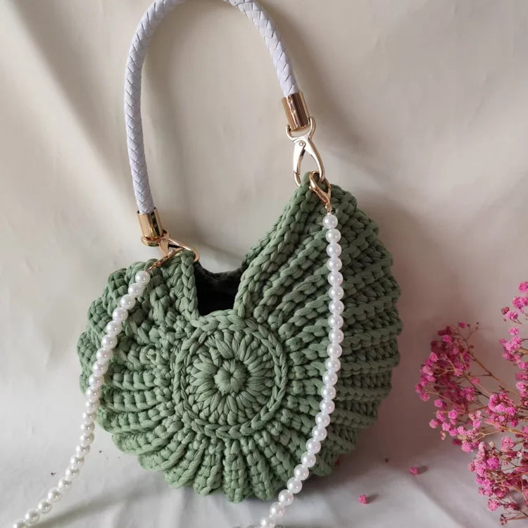 Fossil Seashell Bag in green soft woven cotton with shell shape by Montipi, styled in earthy beach tones – perfect for boho luxe, coastal chic, and summer outfits.