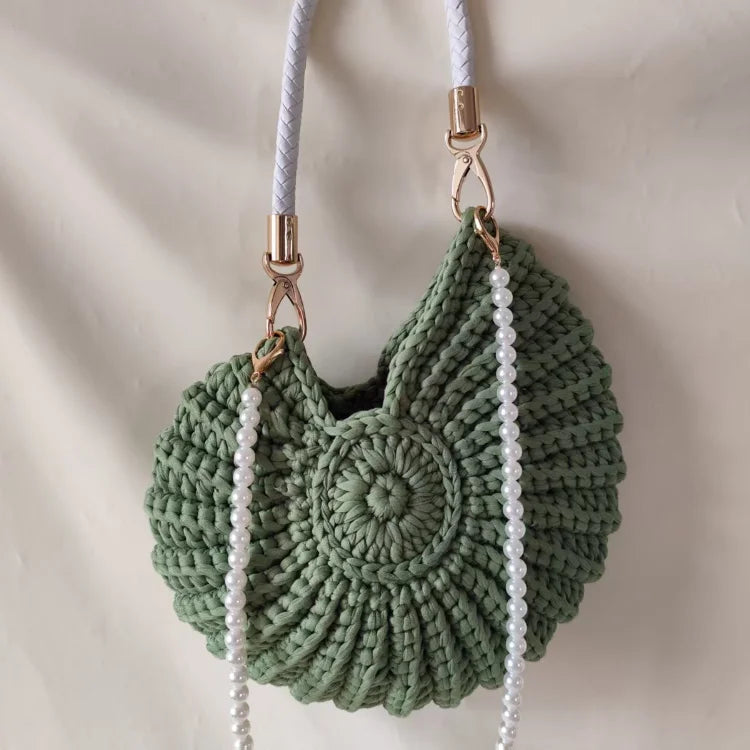 Fossil Seashell Bag in green soft woven cotton with shell shape by Montipi, styled in earthy beach tones – perfect for boho luxe, coastal chic, and summer outfits.