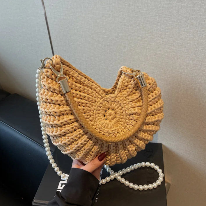 Fossil Seashell Bag in light brown soft woven cotton with shell shape by Montipi, styled in earthy beach tones – perfect for boho luxe, coastal chic, and summer outfits.