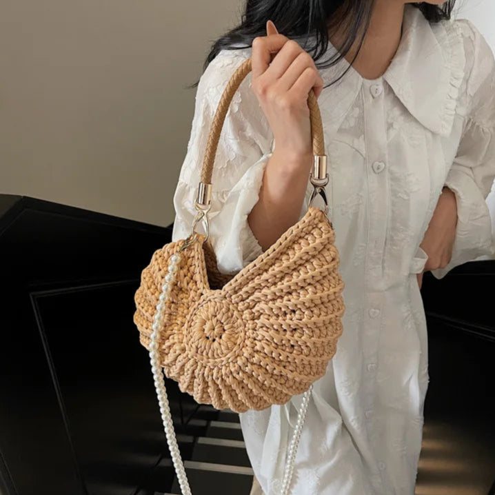 Fossil Seashell Bag in light brown soft woven cotton with shell shape by Montipi, styled in earthy beach tones – perfect for boho luxe, coastal chic, and summer outfits.