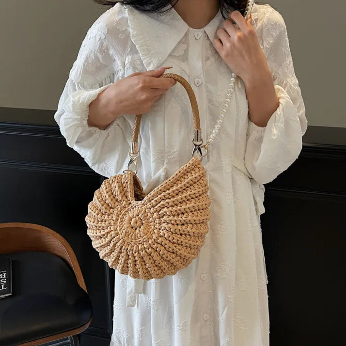 Fossil Seashell Bag in light brown soft woven cotton with shell shape by Montipi, styled in earthy beach tones – perfect for boho luxe, coastal chic, and summer outfits.