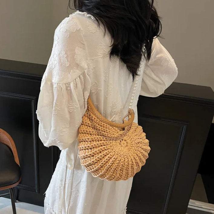 Fossil Seashell Bag in light brown soft woven cotton with shell shape by Montipi, styled in earthy beach tones – perfect for boho luxe, coastal chic, and summer outfits.