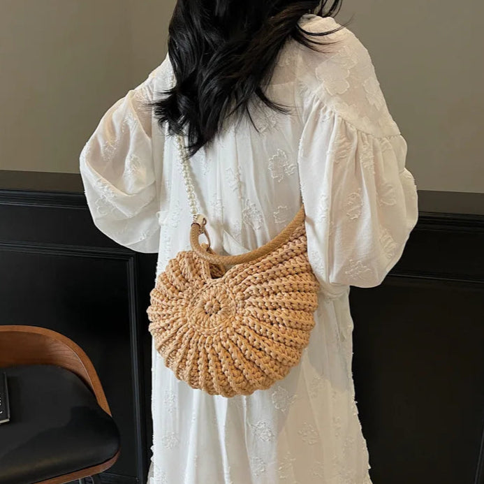 Fossil Seashell Bag in light brown soft woven cotton with shell shape by Montipi, styled in earthy beach tones – perfect for boho luxe, coastal chic, and summer outfits.