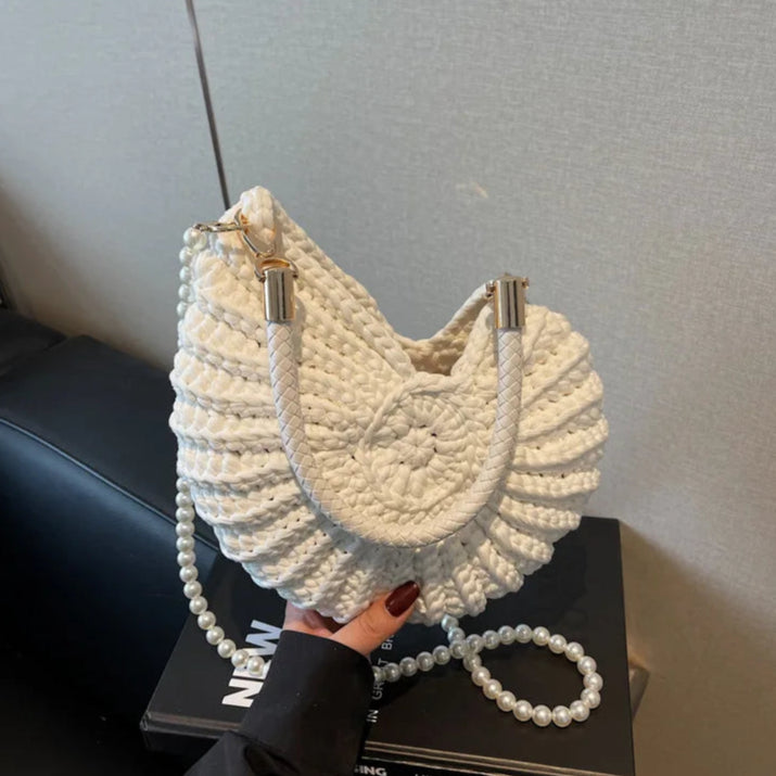 Fossil Seashell Bag in white soft woven cotton with shell shape by Montipi, styled in earthy beach tones – perfect for boho luxe, coastal chic, and summer outfits.