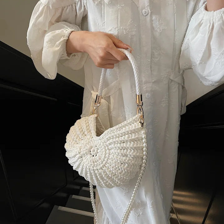 Fossil Seashell Bag in white soft woven cotton with shell shape by Montipi, styled in earthy beach tones – perfect for boho luxe, coastal chic, and summer outfits.