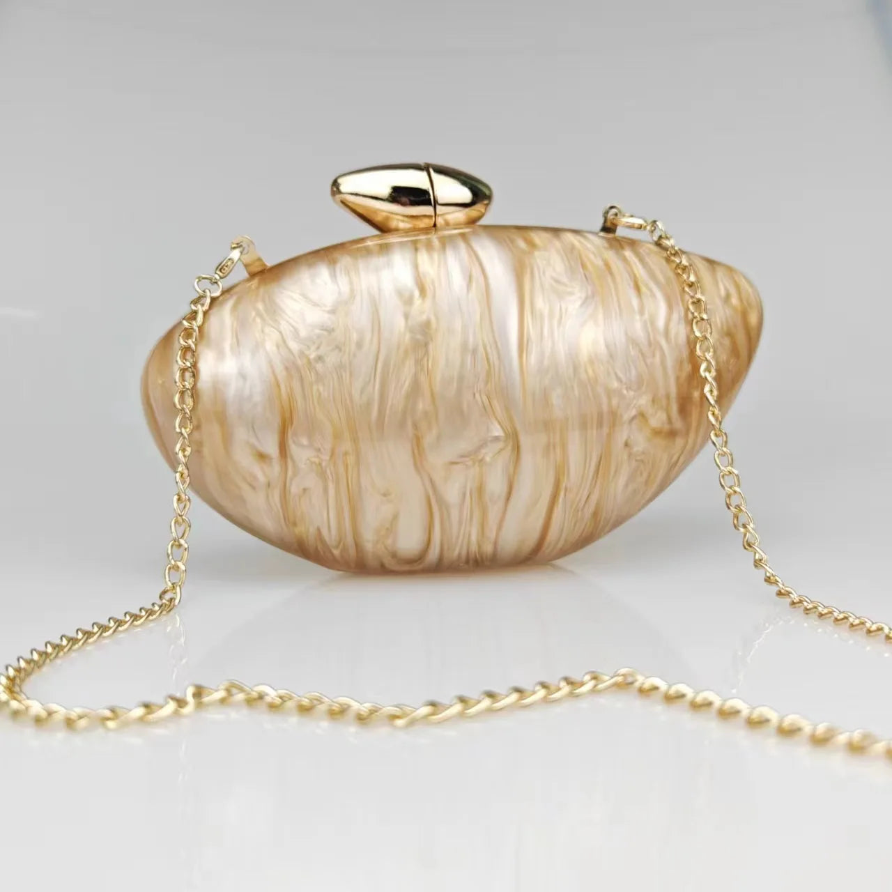 gold seashell clutch bag with a dreamy pearl acrylic finish, gold hasp closure, and chain strap – perfect for weddings, soirées, and beachside style by Montipi Australia