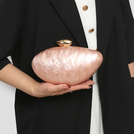 Soft pink seashell clutch bag with a dreamy pearl acrylic finish, gold hasp closure, and chain strap – perfect for weddings, soirées, and beachside style by Montipi Australia
