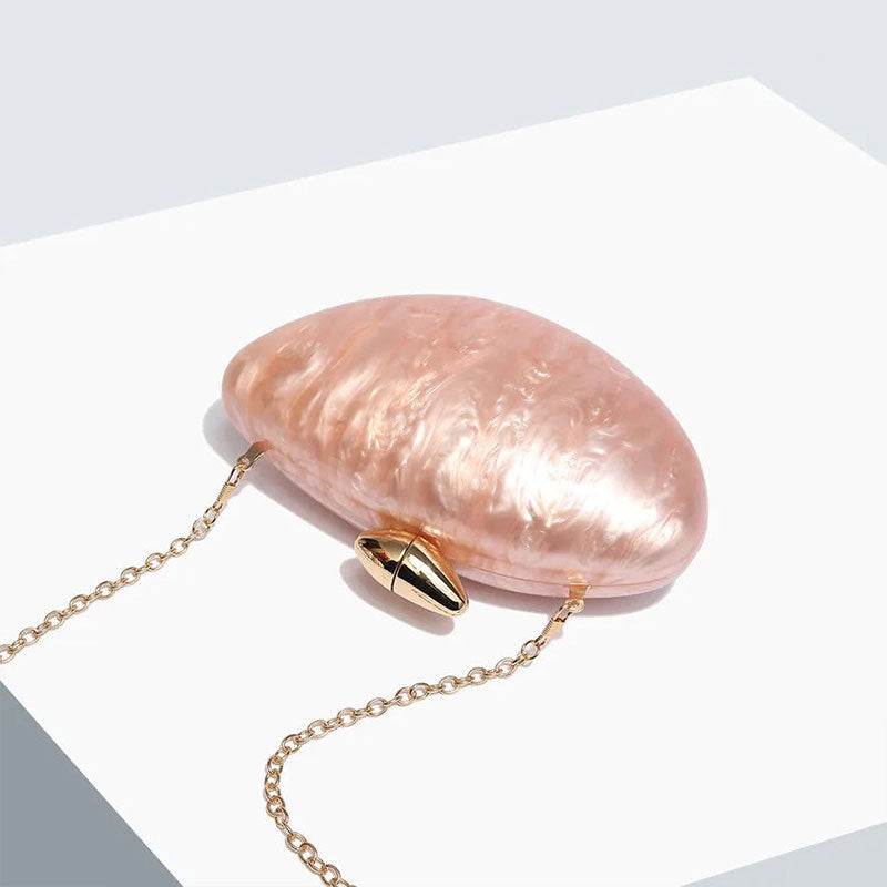 Soft pink seashell clutch bag with a dreamy pearl acrylic finish, gold hasp closure, and chain strap – perfect for weddings, soirées, and beachside style by Montipi Australia