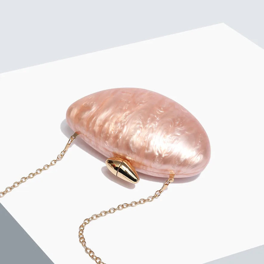 Soft pink seashell clutch bag with a dreamy pearl acrylic finish, gold hasp closure, and chain strap – perfect for weddings, soirées, and beachside style by Montipi Australia