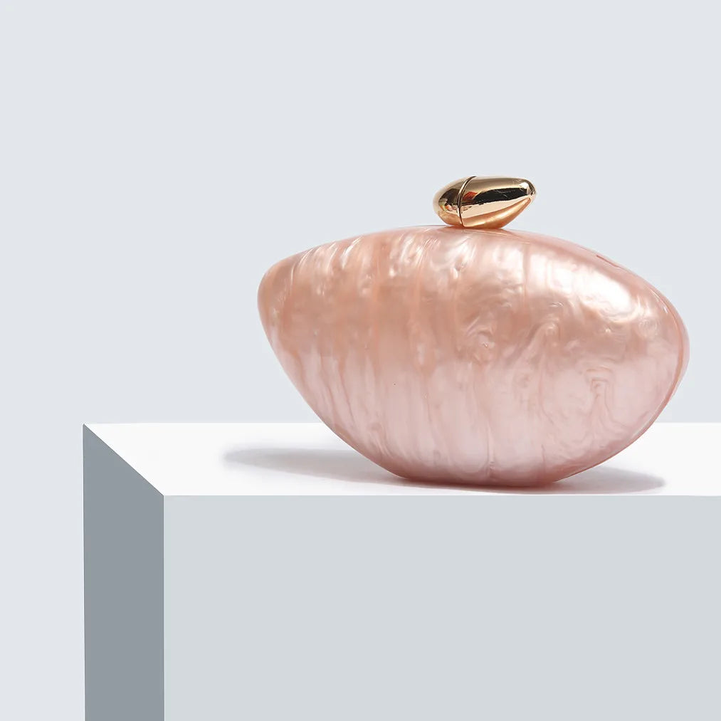 Soft pink seashell clutch bag with a dreamy pearl acrylic finish, gold hasp closure, and chain strap – perfect for weddings, soirées, and beachside style by Montipi Australia