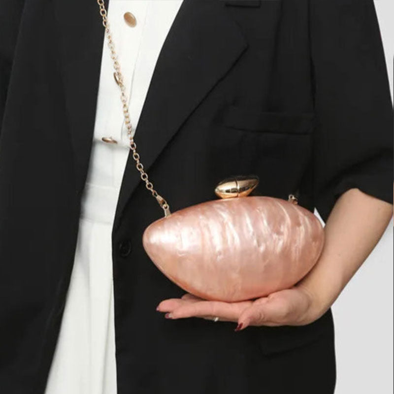 Soft pink seashell clutch bag with a dreamy pearl acrylic finish, gold hasp closure, and chain strap – perfect for weddings, soirées, and beachside style by Montipi Australia