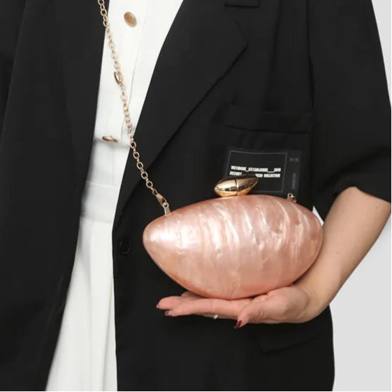 Soft pink seashell clutch bag with a dreamy pearl acrylic finish, gold hasp closure, and chain strap – perfect for weddings, soirées, and beachside style by Montipi Australia