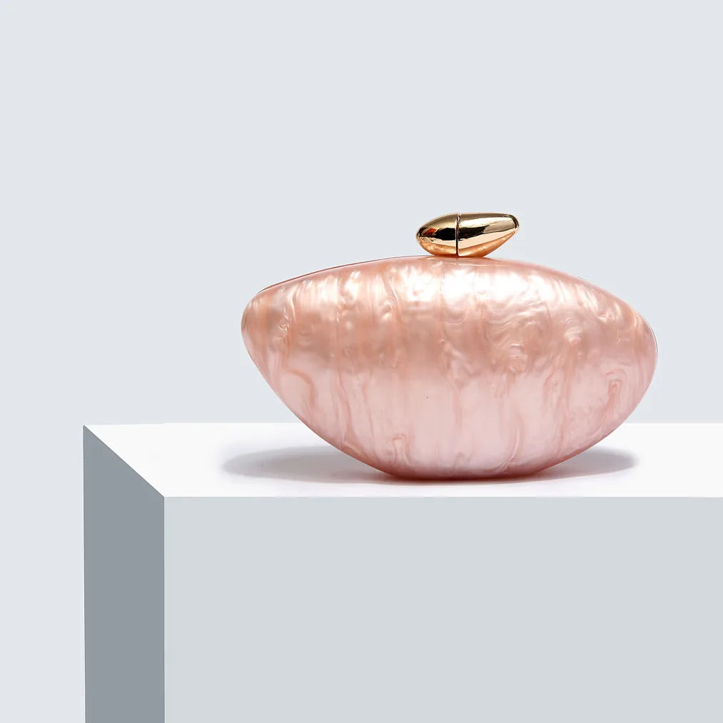 Soft pink seashell clutch bag with a dreamy pearl acrylic finish, gold hasp closure, and chain strap – perfect for weddings, soirées, and beachside style by Montipi Australia