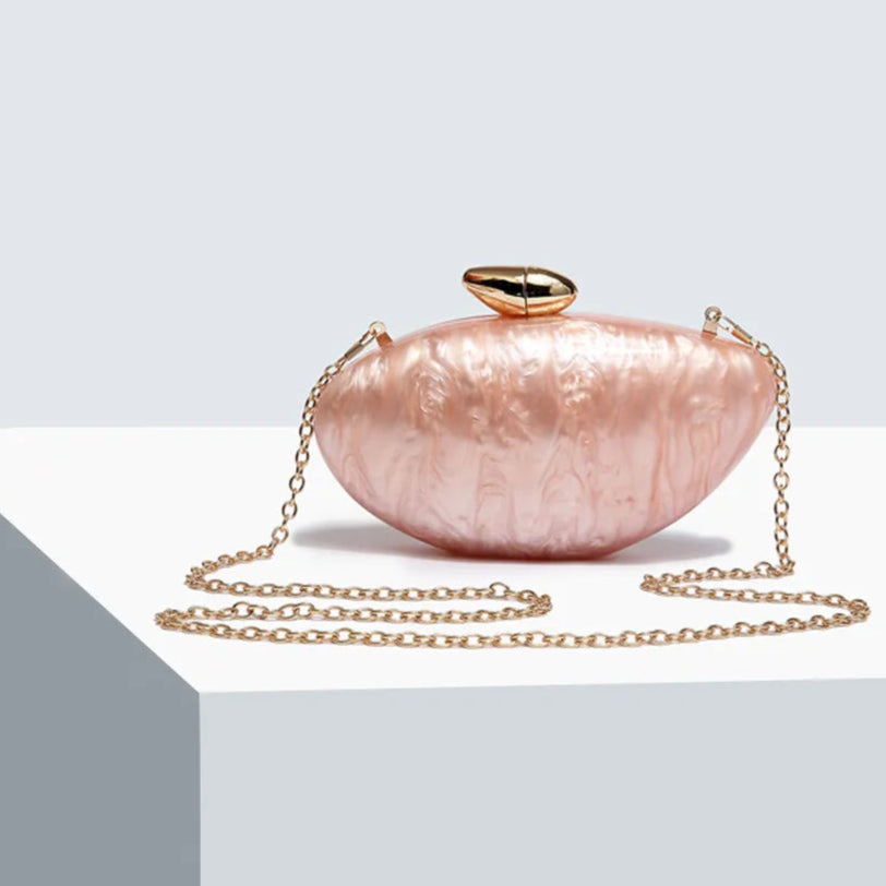 Soft pink seashell clutch bag with a dreamy pearl acrylic finish, gold hasp closure, and chain strap – perfect for weddings, soirées, and beachside style by Montipi Australia