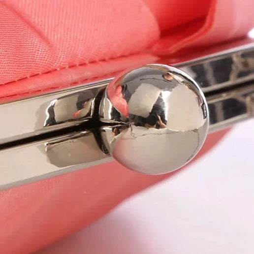 Close up of the hasp button closure in silver of the Rose Chic Petal Clutch Bag. a delicate rose-shaped clutch bag with layered petal detailing in a soft, romantic hue. The elegant floral design mimics the texture of blooming petals, creating a timeless statement piece. Set against a refined backdrop, the clutch exudes femininity and sophistication, perfect for weddings, cocktail events, and special occasions. Rose Chic Petal Clutch Bag in rose pink by Montipi Australia