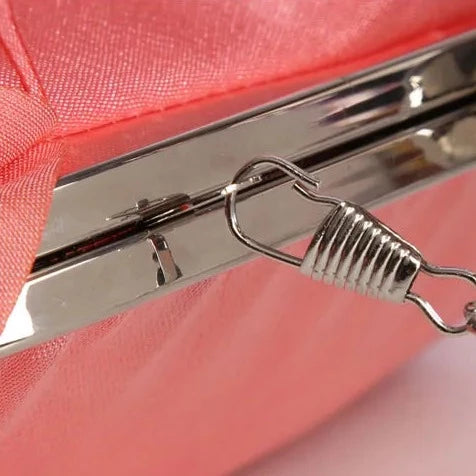 Close up of the removable strap in silver of the Rose Chic Petal Clutch Bag. a delicate rose-shaped clutch bag with layered petal detailing in a soft, romantic hue. The elegant floral design mimics the texture of blooming petals, creating a timeless statement piece. Set against a refined backdrop, the clutch exudes femininity and sophistication, perfect for weddings, cocktail events, and special occasions. Rose Chic Petal Clutch Bag in rose pink by Montipi Australia