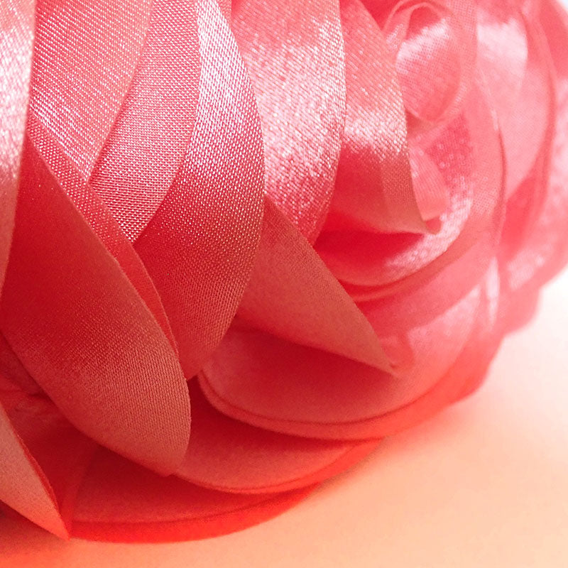 Close up of the Rose Chic Petal Clutch. A delicate rose-shaped clutch bag with layered petal detailing in a soft, romantic hue. The elegant floral design mimics the texture of blooming petals, creating a timeless statement piece. Set against a refined backdrop, the clutch exudes femininity and sophistication, perfect for weddings, cocktail events, and special occasions. Rose Chic Petal Clutch Bag in rose pink by Montipi Australia