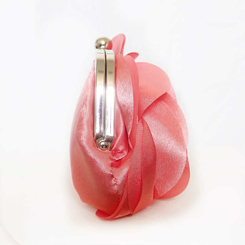 Lateral view of delicate rose-shaped clutch bag with layered petal detailing in a soft, romantic hue. The elegant floral design mimics the texture of blooming petals, creating a timeless statement piece. Set against a refined backdrop, the clutch exudes femininity and sophistication, perfect for weddings, cocktail events, and special occasions. Rose Chic Petal Clutch Bag in rose pink by Montipi Australia