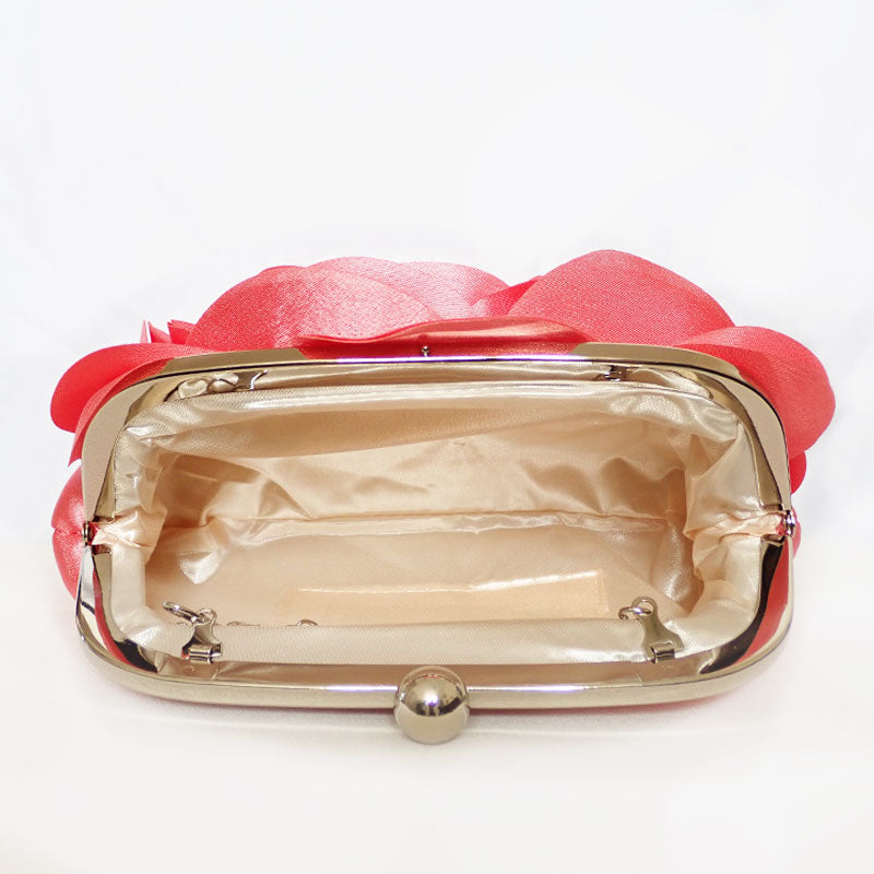 Front view showing the interior of the Rose Chic Petal Clutch in a Couture pose. A delicate rose-shaped clutch bag with layered petal detailing in a soft, romantic hue. The elegant floral design mimics the texture of blooming petals, creating a timeless statement piece. Set against a refined backdrop, the clutch exudes femininity and sophistication, perfect for weddings, cocktail events, and special occasions. Rose Chic Petal Clutch Bag in rose pink by Montipi Australia