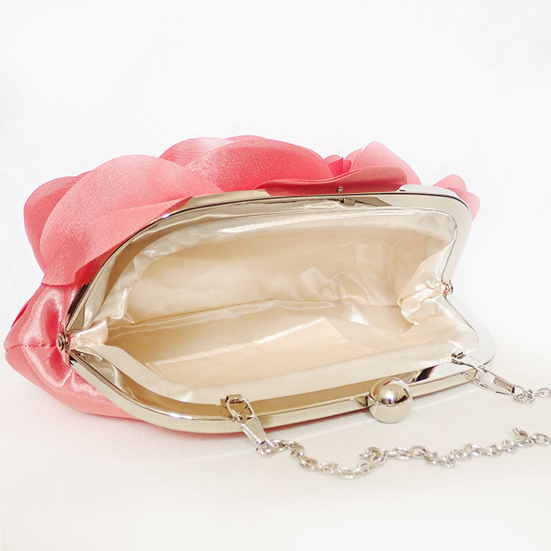 Angled view showing the interior the Rose Chic Petal Clutch in a Couture pose. A delicate rose-shaped clutch bag with layered petal detailing in a soft, romantic hue. The elegant floral design mimics the texture of blooming petals, creating a timeless statement piece. Set against a refined backdrop, the clutch exudes femininity and sophistication, perfect for weddings, cocktail events, and special occasions. Rose Chic Petal Clutch Bag in rose pink by Montipi Australia