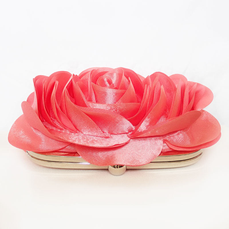 Front top view of the Rose Chic Petal Clutch in a Couture pose. A delicate rose-shaped clutch bag with layered petal detailing in a soft, romantic hue. The elegant floral design mimics the texture of blooming petals, creating a timeless statement piece. Set against a refined backdrop, the clutch exudes femininity and sophistication, perfect for weddings, cocktail events, and special occasions. Rose Chic Petal Clutch Bag in rose pink by Montipi Australia