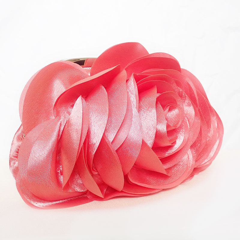 side view of delicate rose-shaped clutch bag with layered petal detailing in a soft, romantic hue. The elegant floral design mimics the texture of blooming petals, creating a timeless statement piece. Set against a refined backdrop, the clutch exudes femininity and sophistication, perfect for weddings, cocktail events, and special occasions. Rose Chic Petal Clutch Bag in rose pink by Montipi Australia