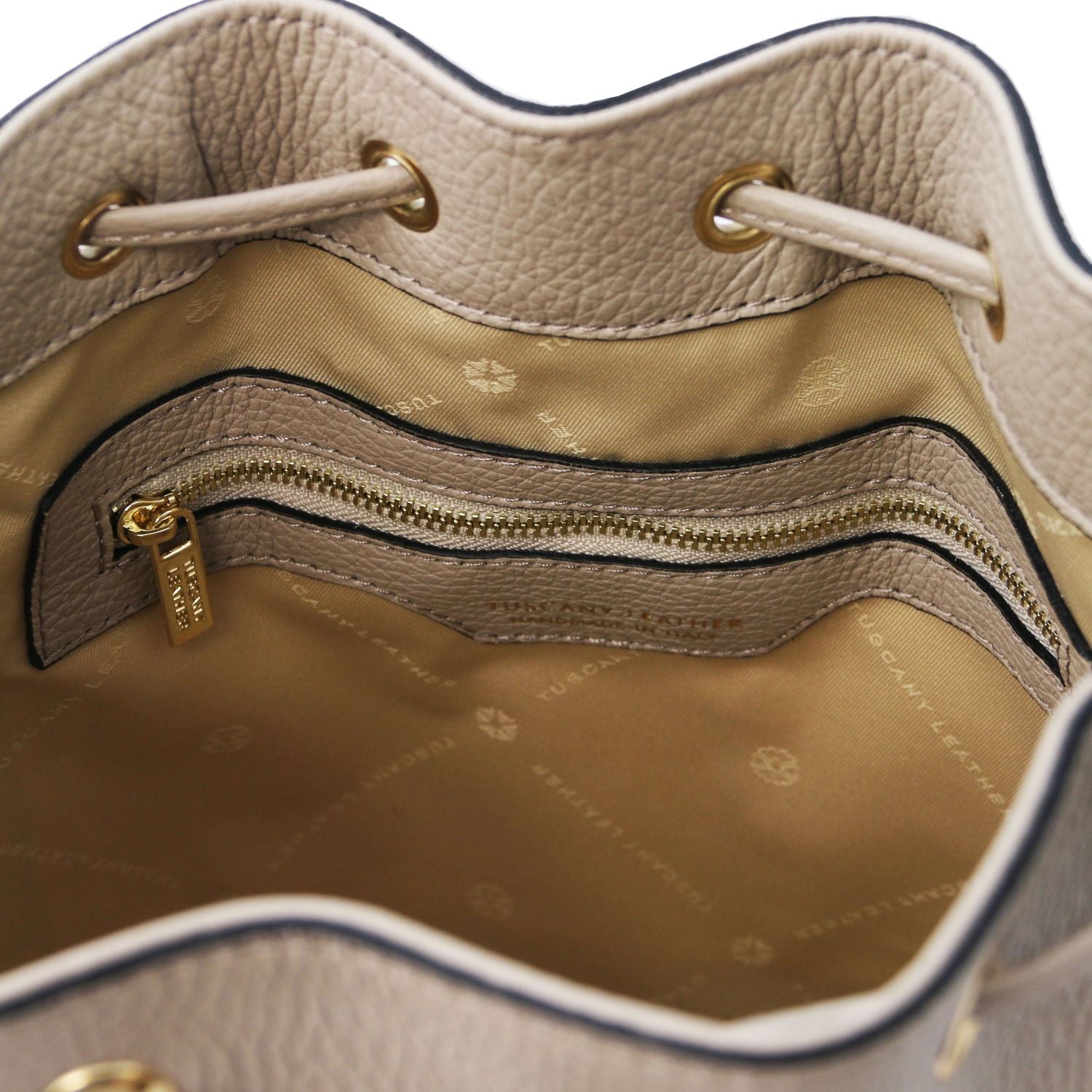 Interior view of the TL Leather Bucket Bag in beige light taupe by Montipi Australia, featuring a beige lining, spacious compartment, and secure internal zip pocket. Crafted from premium Italian pebbled leather with gold-tone hardware, this chic bucket bag blends elegance with everyday practicality.