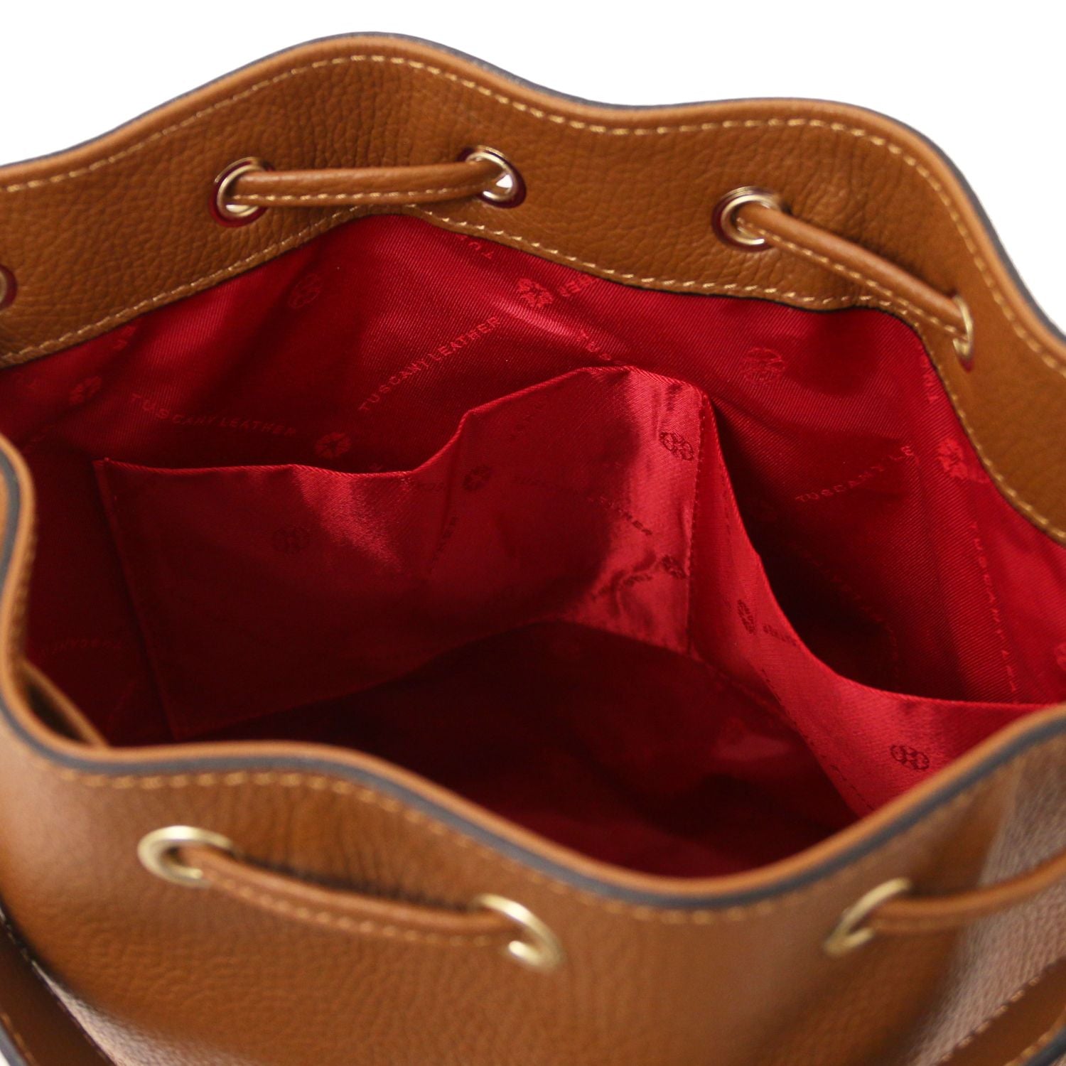 Interior view of the TL Leather Bucket Bag in cognac brown by Montipi Australia, showcasing the bold red lining, dual slide pockets, and spacious compartment for effortless organization. Crafted from premium Italian pebbled leather with gold-tone hardware, this elegant bucket bag combines sophistication with practicality