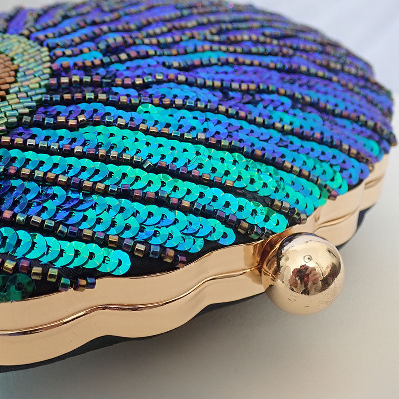 Close up on Teal Sequin Peacock Clutch with detailed beadwork design in feather shape and gold tone hardware, unique statement clutch bag elegant whimsical eclectic chic style by Montipi Australia