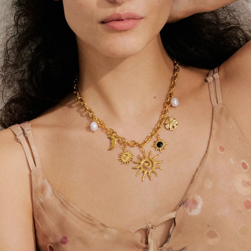 Model wearing the Golden sun and moon charm necklace with pearls – Aurea Sun Charm Necklace by Montipi.
