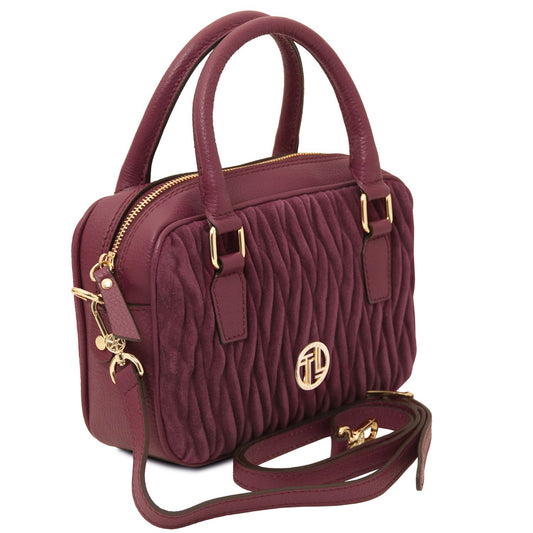 Side view of the Chantilly Suede Handbag in burgundy – a quilted suede Italian leather bag with gold-tone hardware, top handles, and a modern structured silhouette.