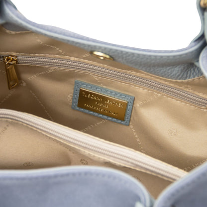 Interior view of engraved TL logo in gold hardware on Diade suede leather shoulder bag in light blue