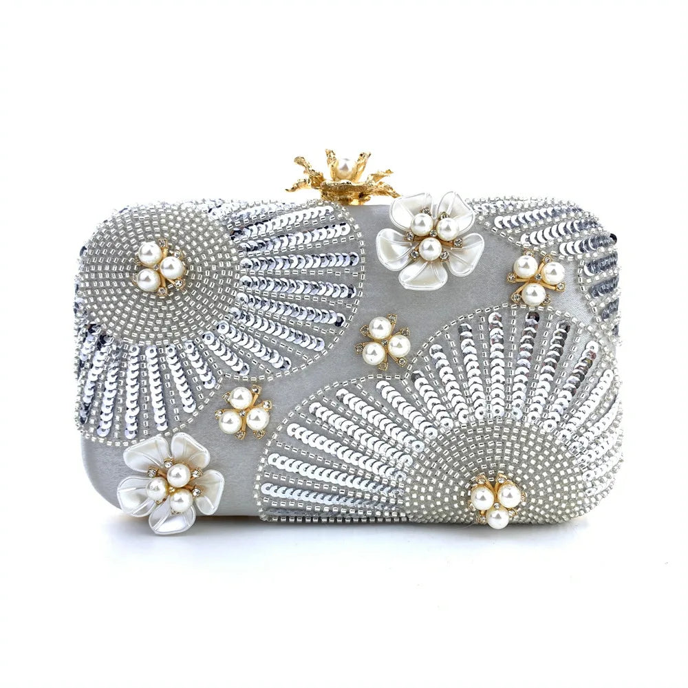Silver clutch bag with floral embellishments on a white background