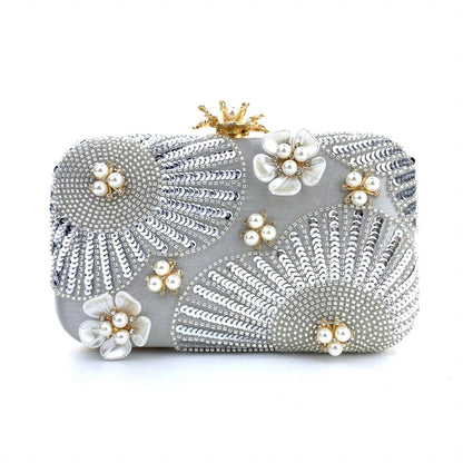 Silver clutch bag with floral embellishments on a white background