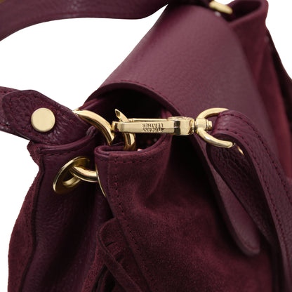 Close-up of the Nomad Burgundy Suede Leather Fringe Bag showing adjustable leather strap, gold-tone hardware, and detailed artisanal stitching by Montipi.