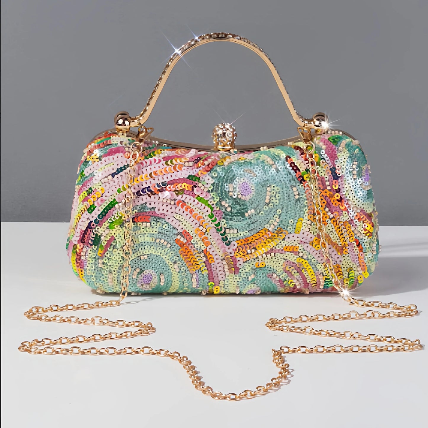 Pastel sequin clutch bag with colourful swirling beadwork in pink, mint and yellow tones with elegant gold handle and chain strap. A whimsical evening bag with vintage glamour and expressive boho style by Montipi