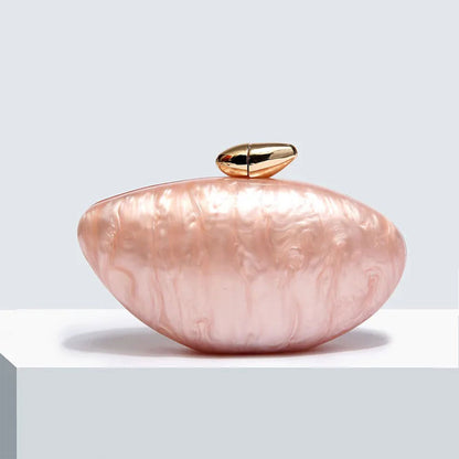 Soft pink seashell clutch bag with a dreamy pearl acrylic finish, gold hasp closure, and chain strap – perfect for weddings, soirées, and beachside style by Montipi Australia