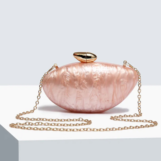 Soft pink seashell clutch bag with a dreamy pearl acrylic finish, gold hasp closure, and chain strap – perfect for weddings, soirées, and beachside style by Montipi Australia